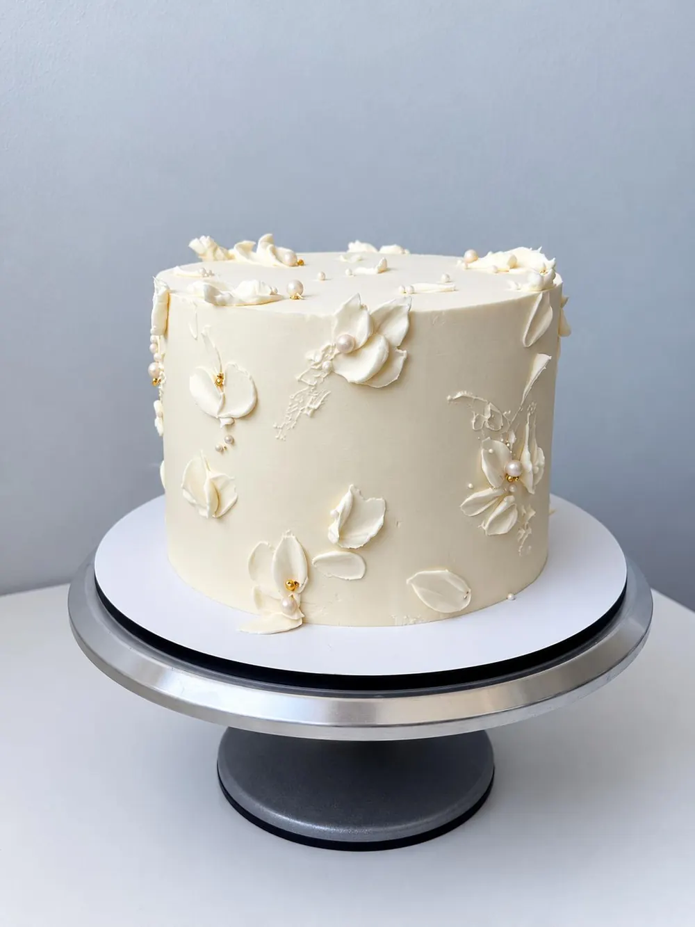 Bijela torta s cvjetnim ukrasima od kreme